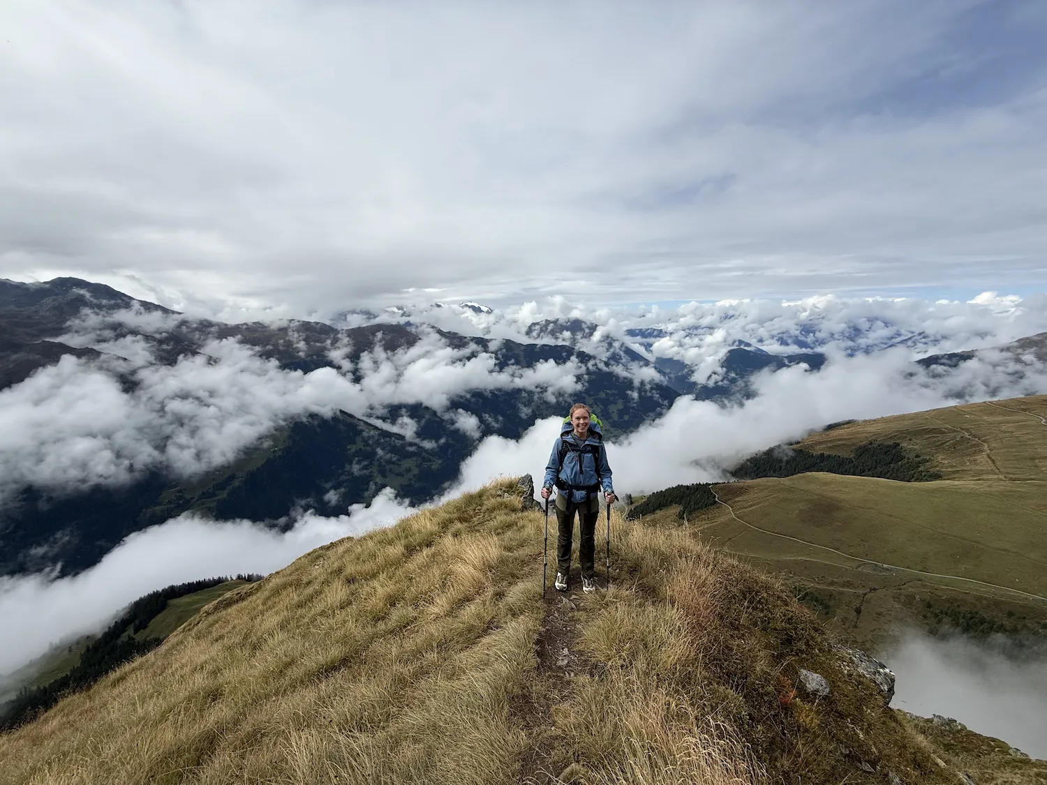 Woman on ledge with clouds in the background