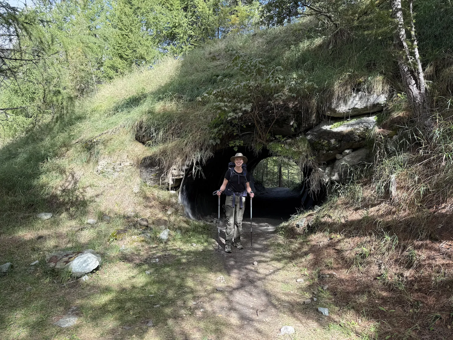 Woman in front of tunnel covered with foliage