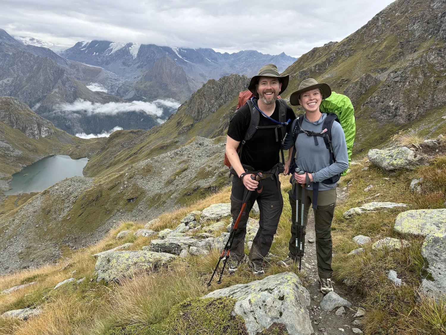 Man and woman standing in front of lake and mountains