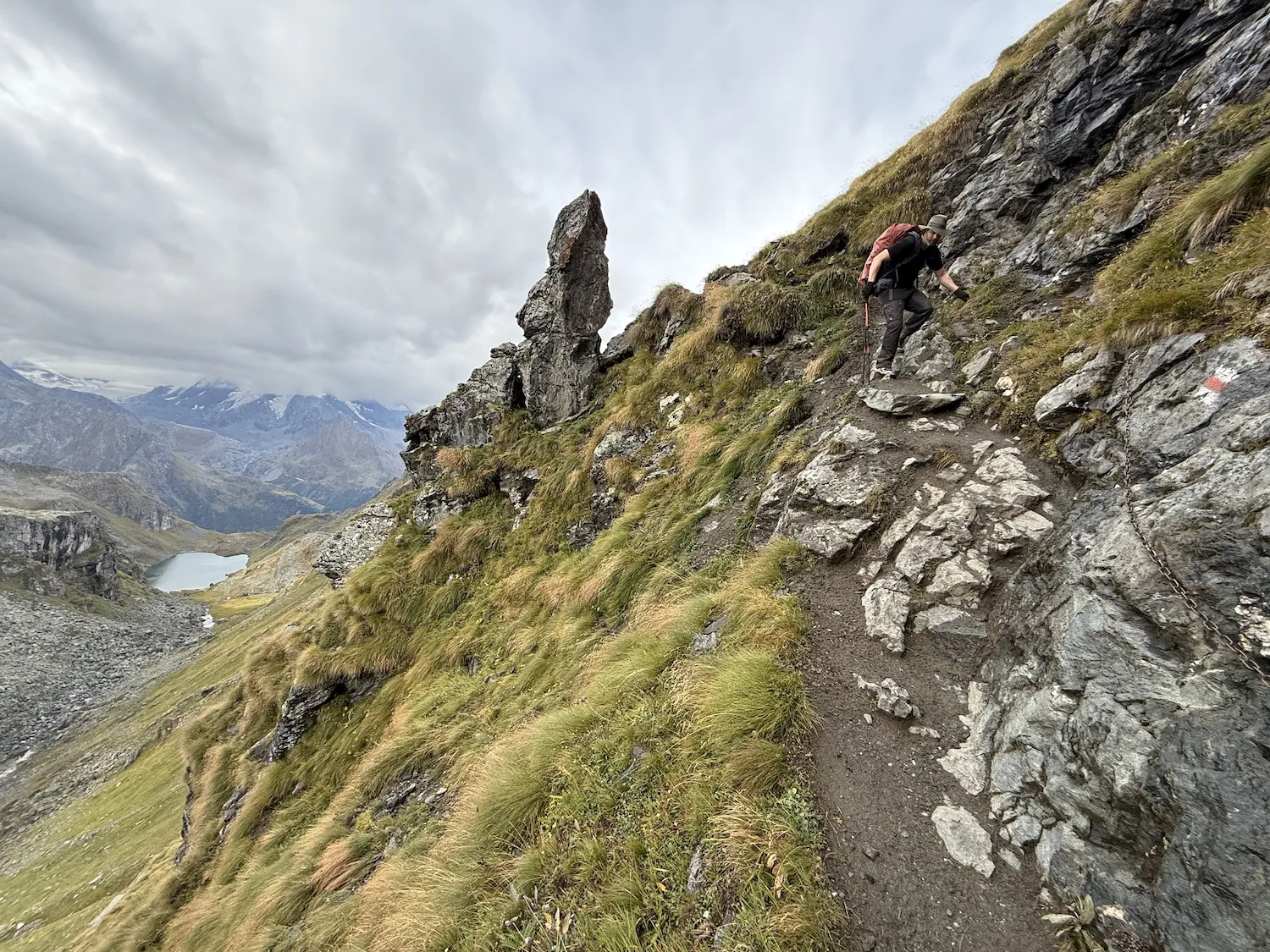 Man using chain to climb down mountain