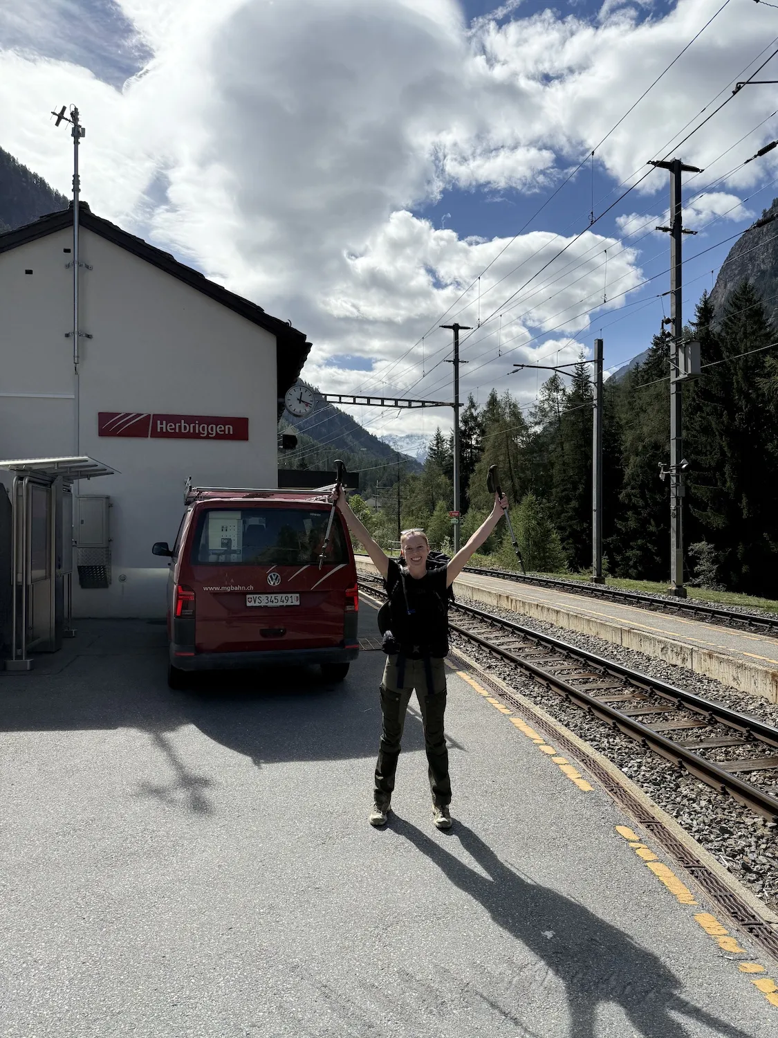Woman with arms up at a train station