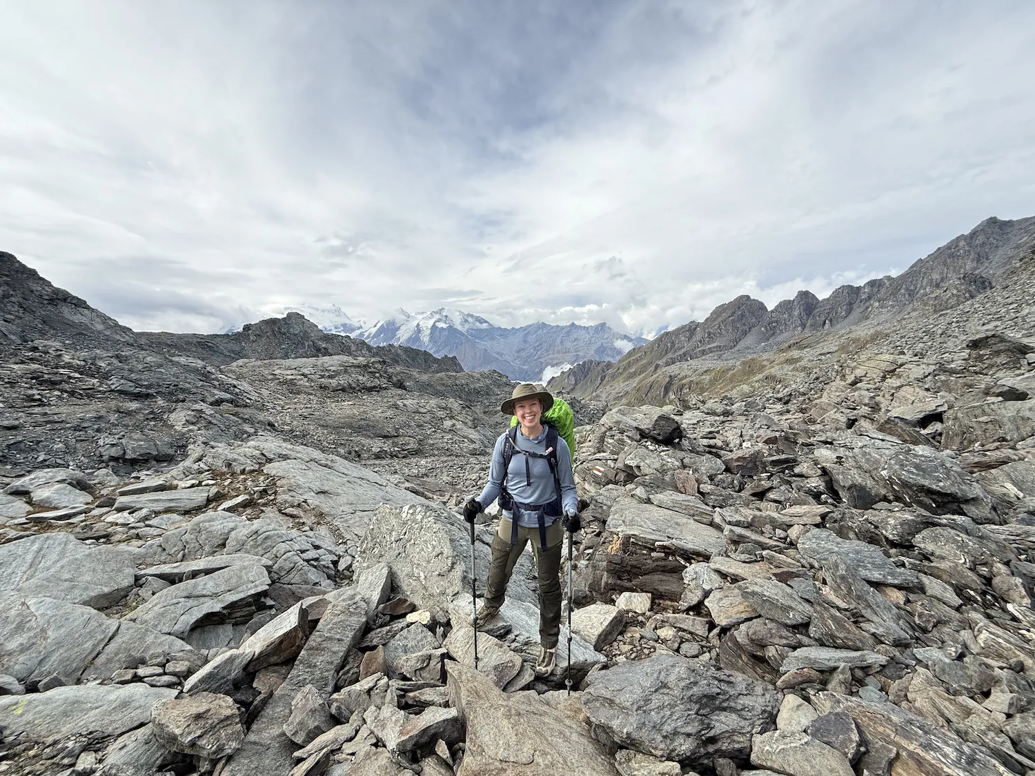 Woman in boulder field with mountains in the background