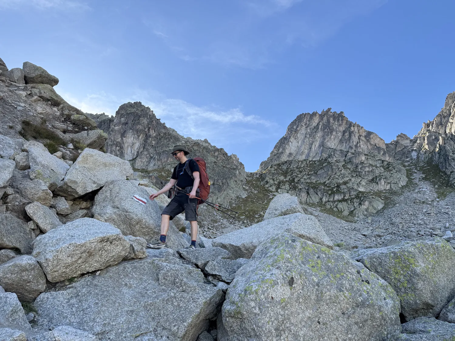 Grant climbing down large boulders