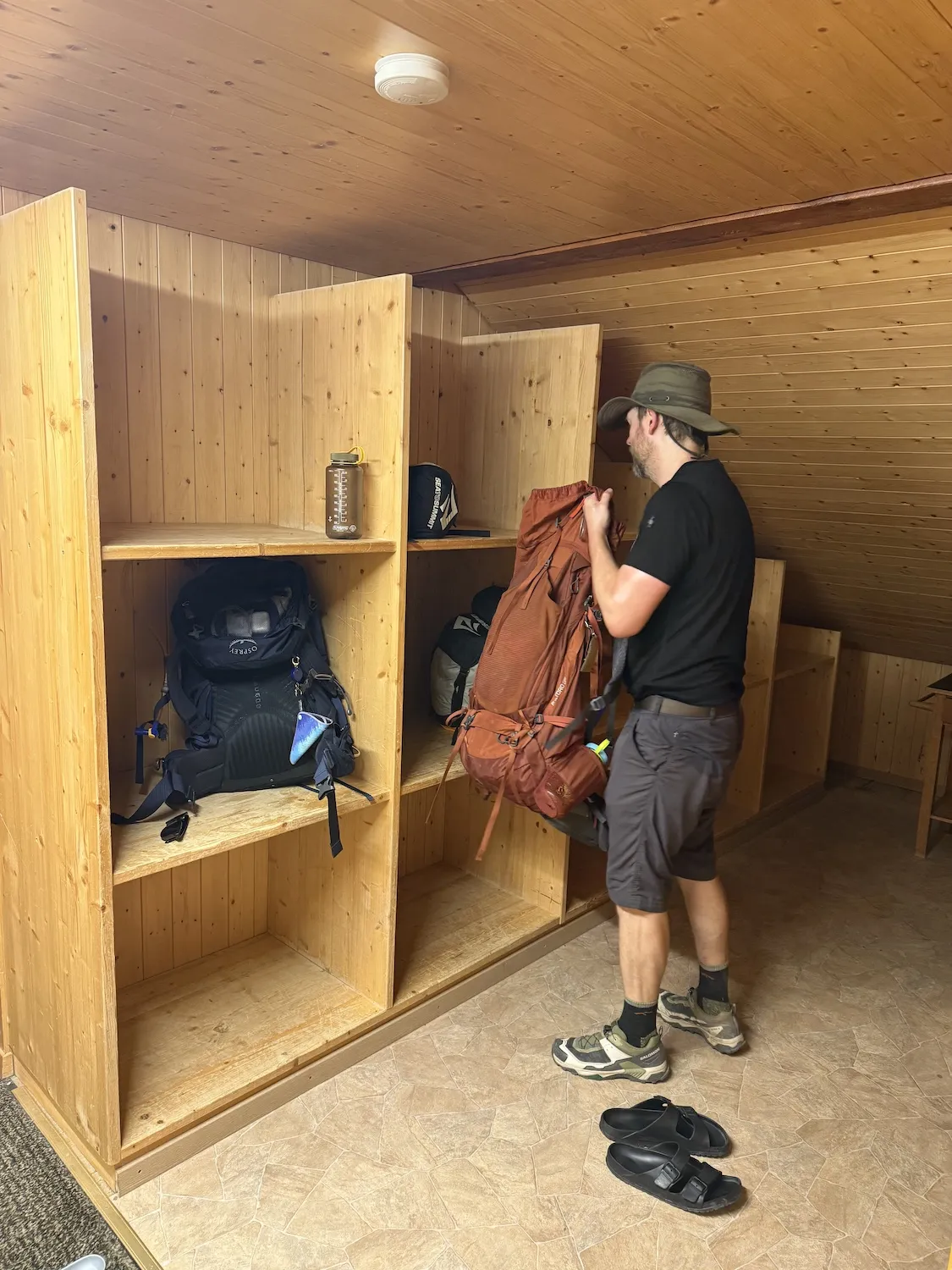 Man putting bag into wooden shelves