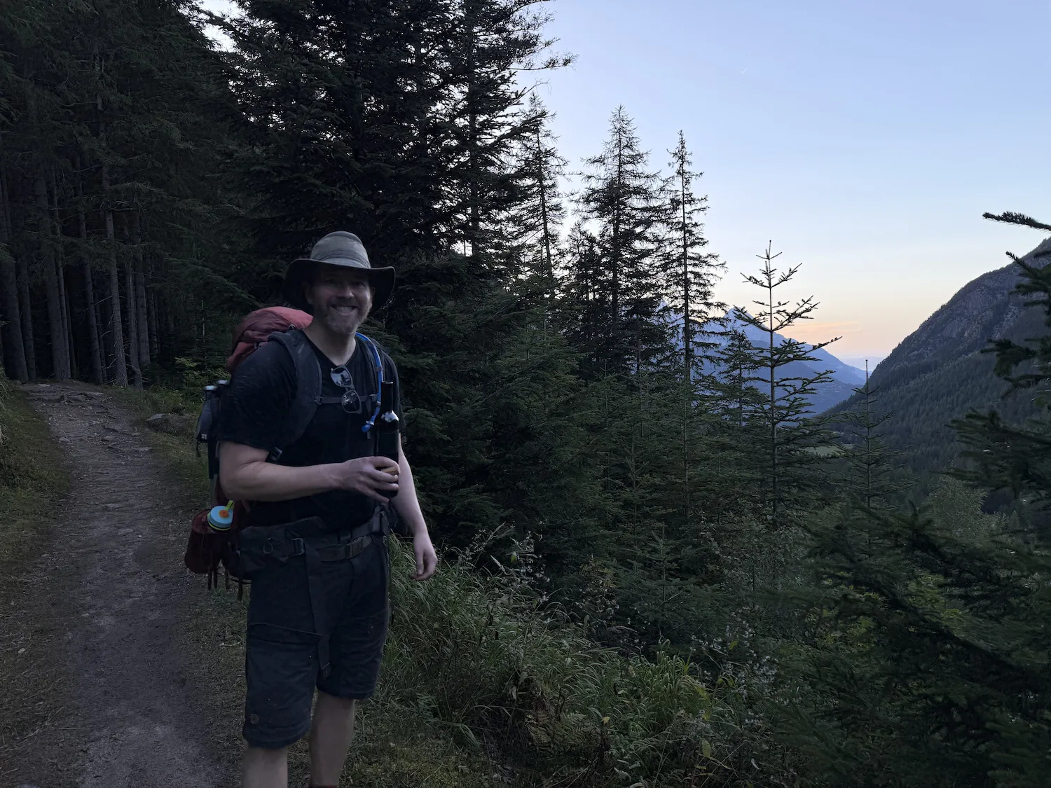 Grant with wine bottle with sunset in the baackground