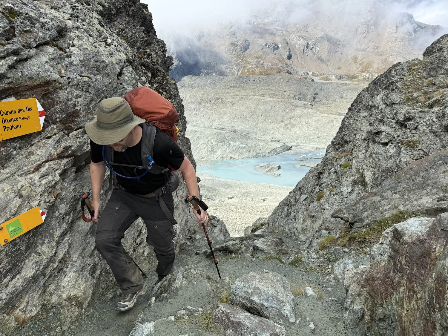 Man climbing with sign next to him