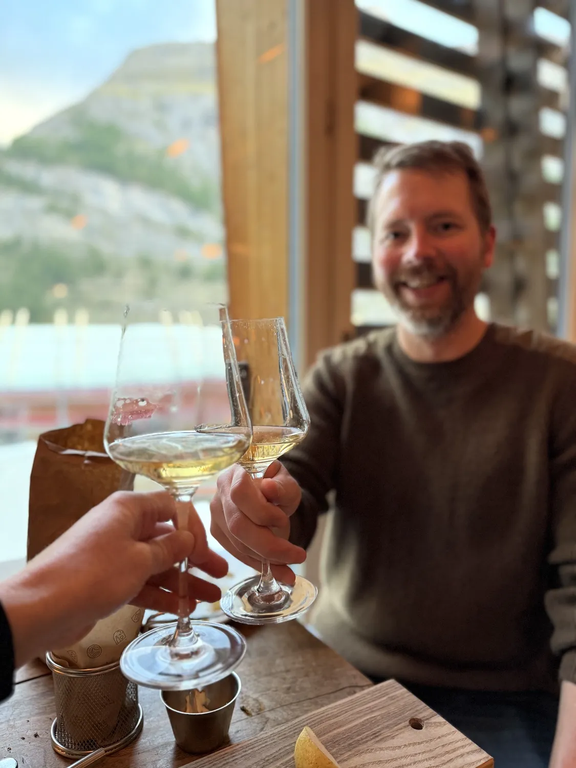 White wine glasses cheersing with man in background