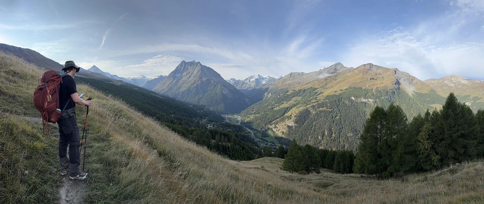 Man looking at phone in front of hills and mountains
