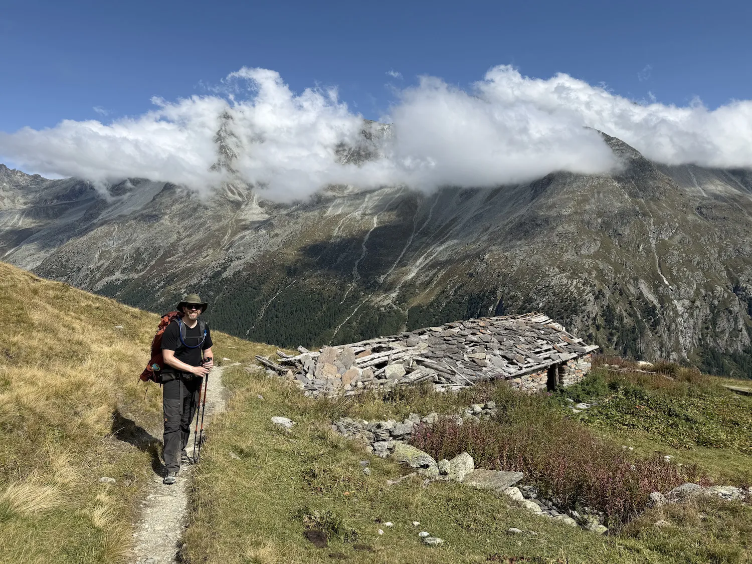 Man next to house with rock roof
