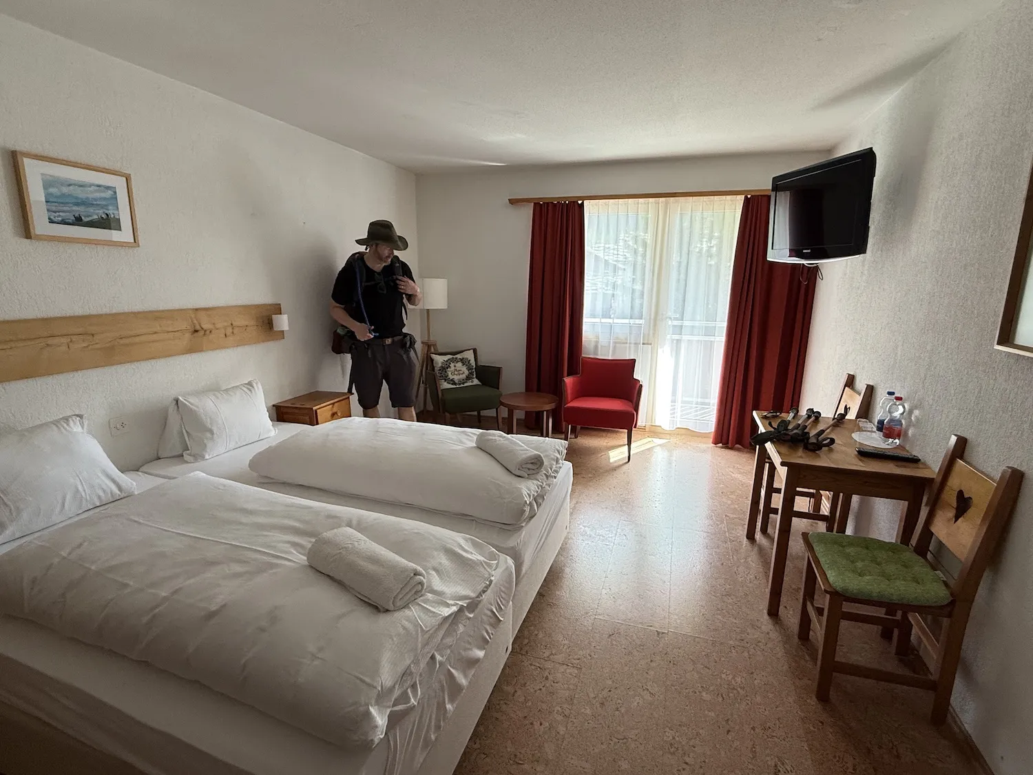 Hotel room with two beds and red curtains