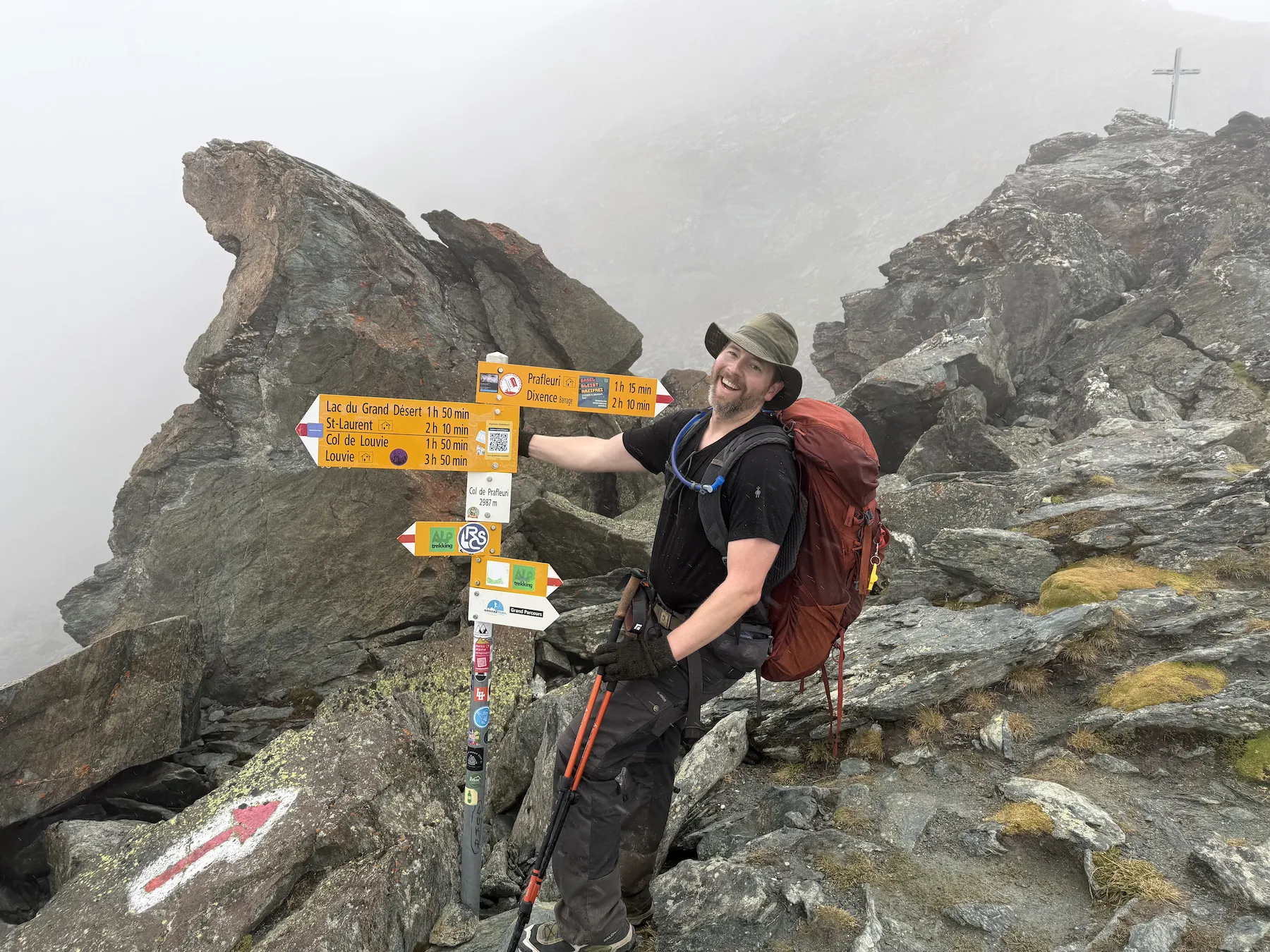 Man hanging on sign with a big smile