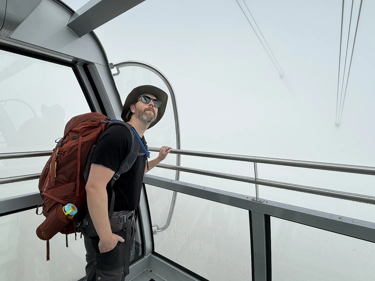 Man on gondola surrounded by clouds