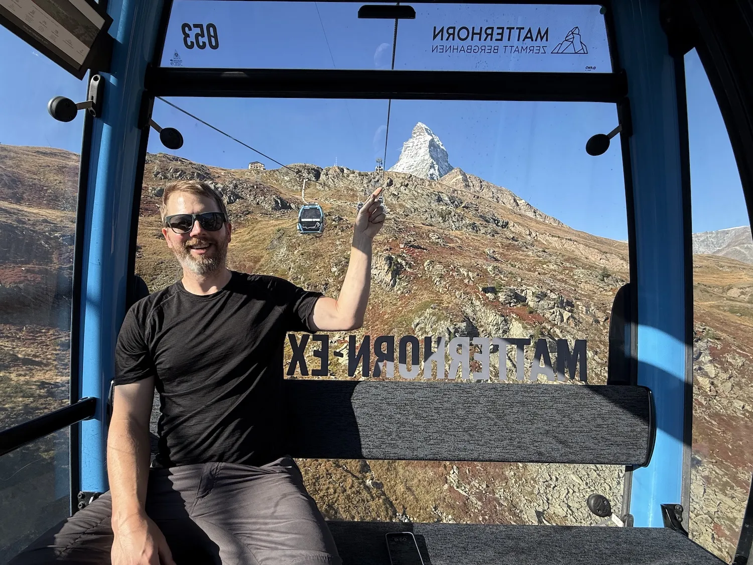 Man on gondola pointing to the Matterhorn