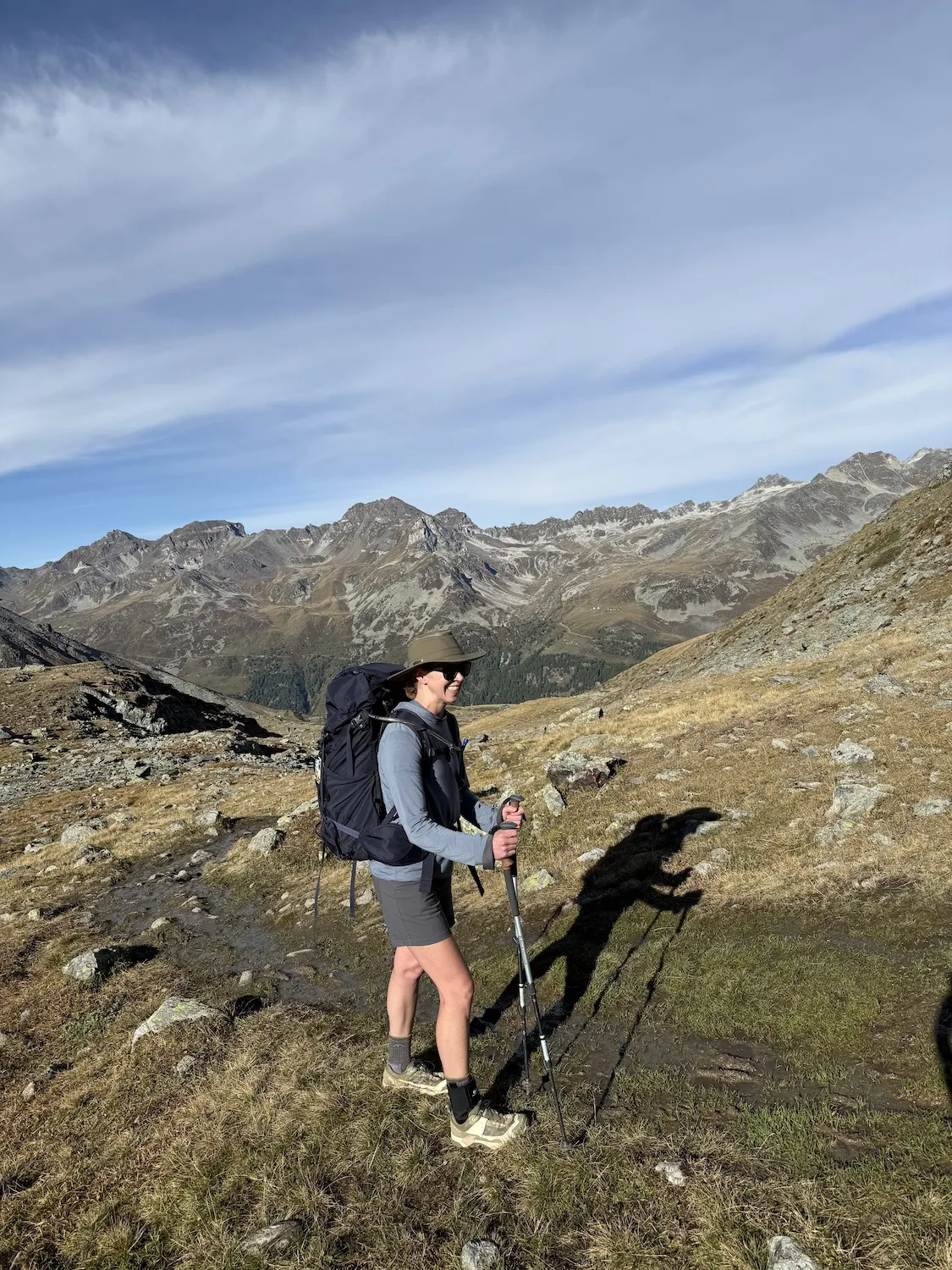 Woman walking in mountains with long shadow