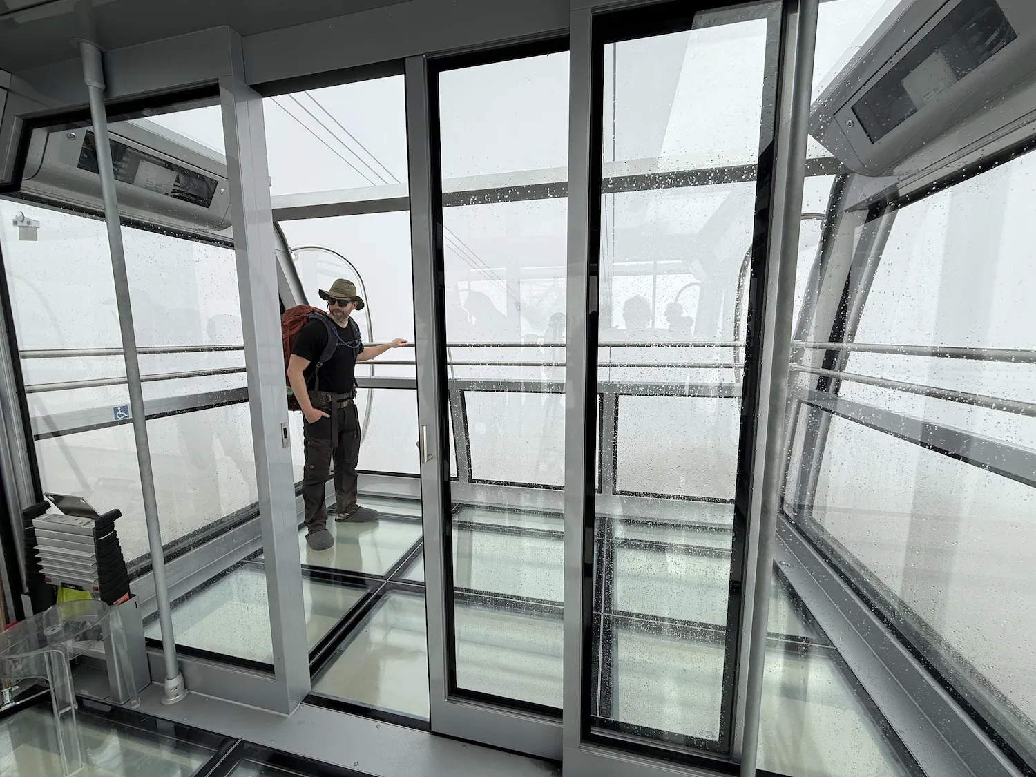 Man in very large glass covered gondola