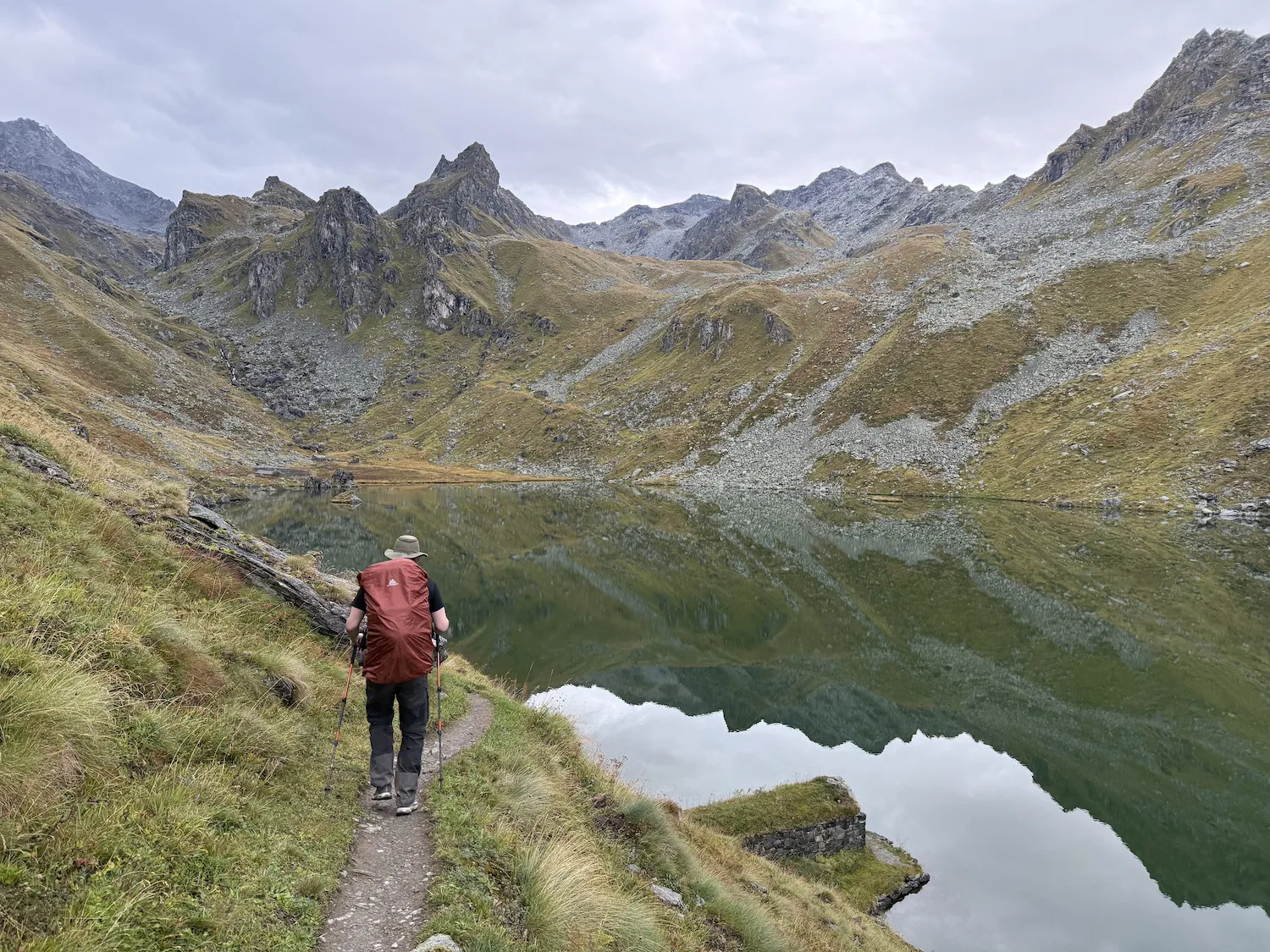Man walking along an alpine lake