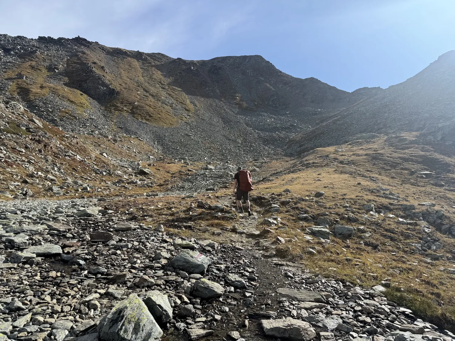Man walking along very rocky terrain