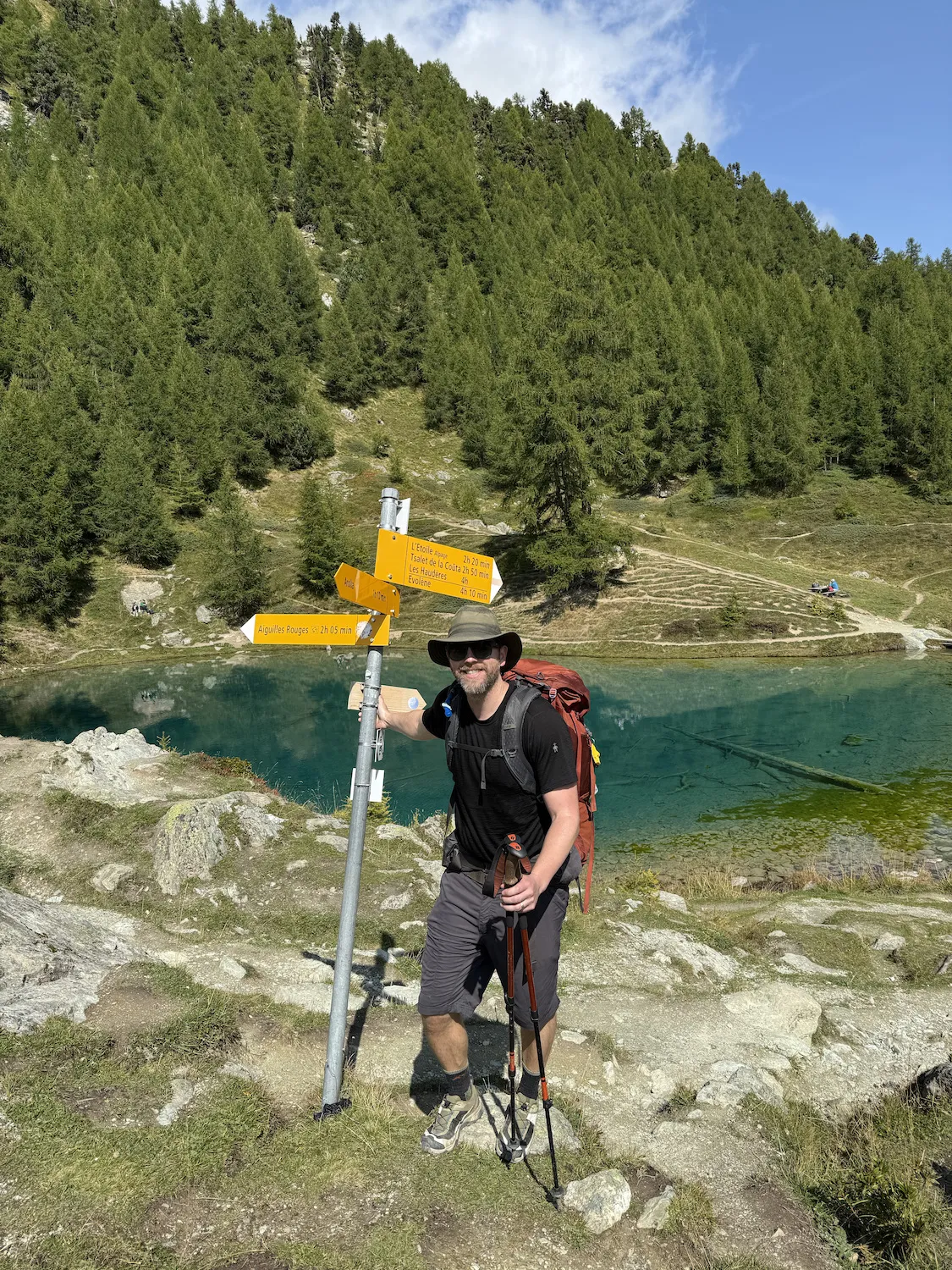 Man next to sign in front of lake