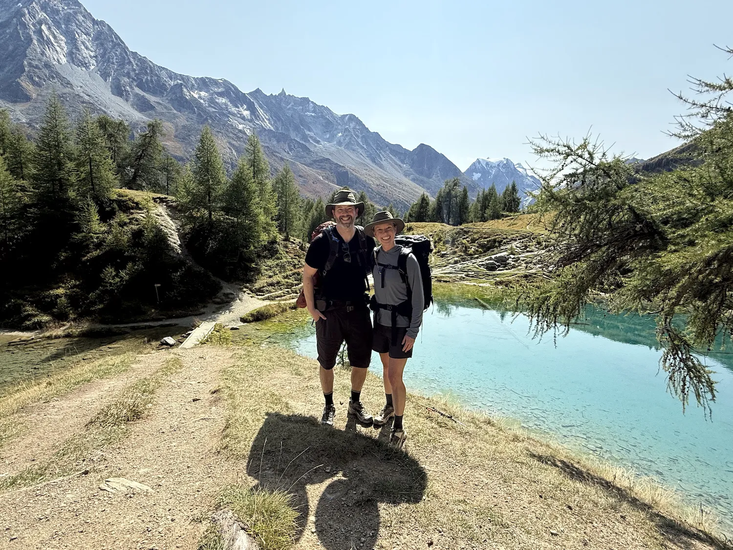 Man and woman in front of blue lake and mountains
