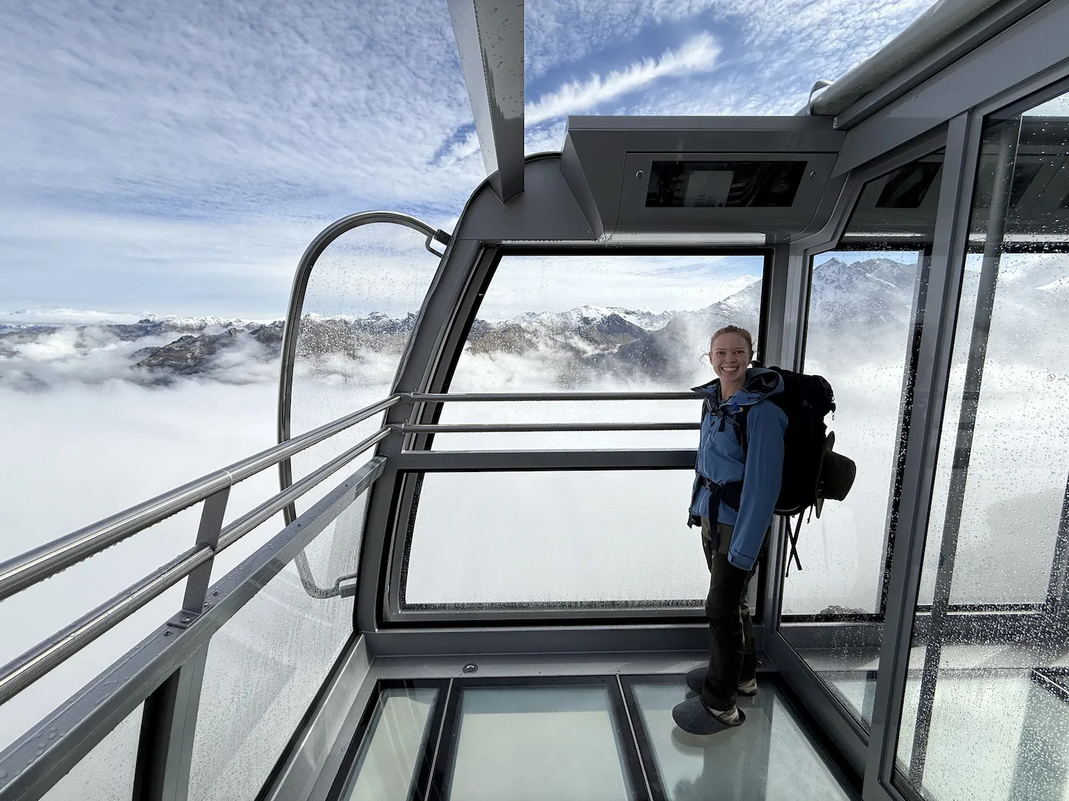 Woman on gondola in front of mountains