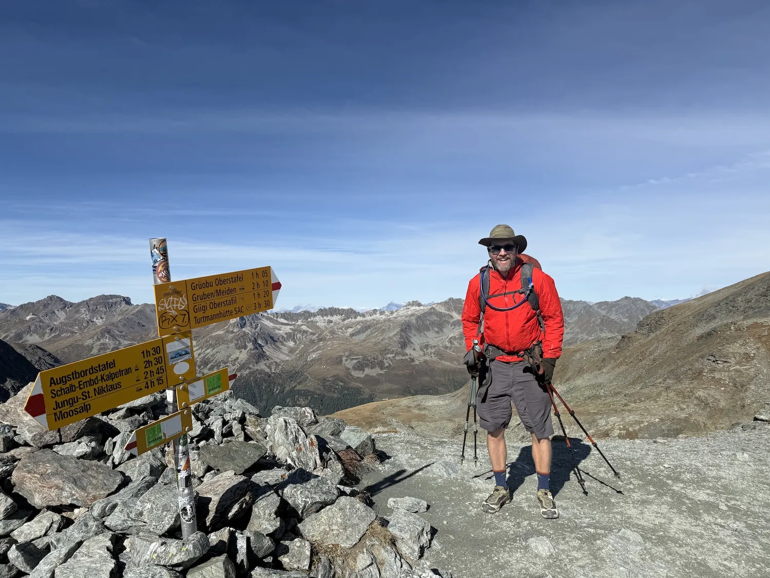 Man next to sign on mountain top