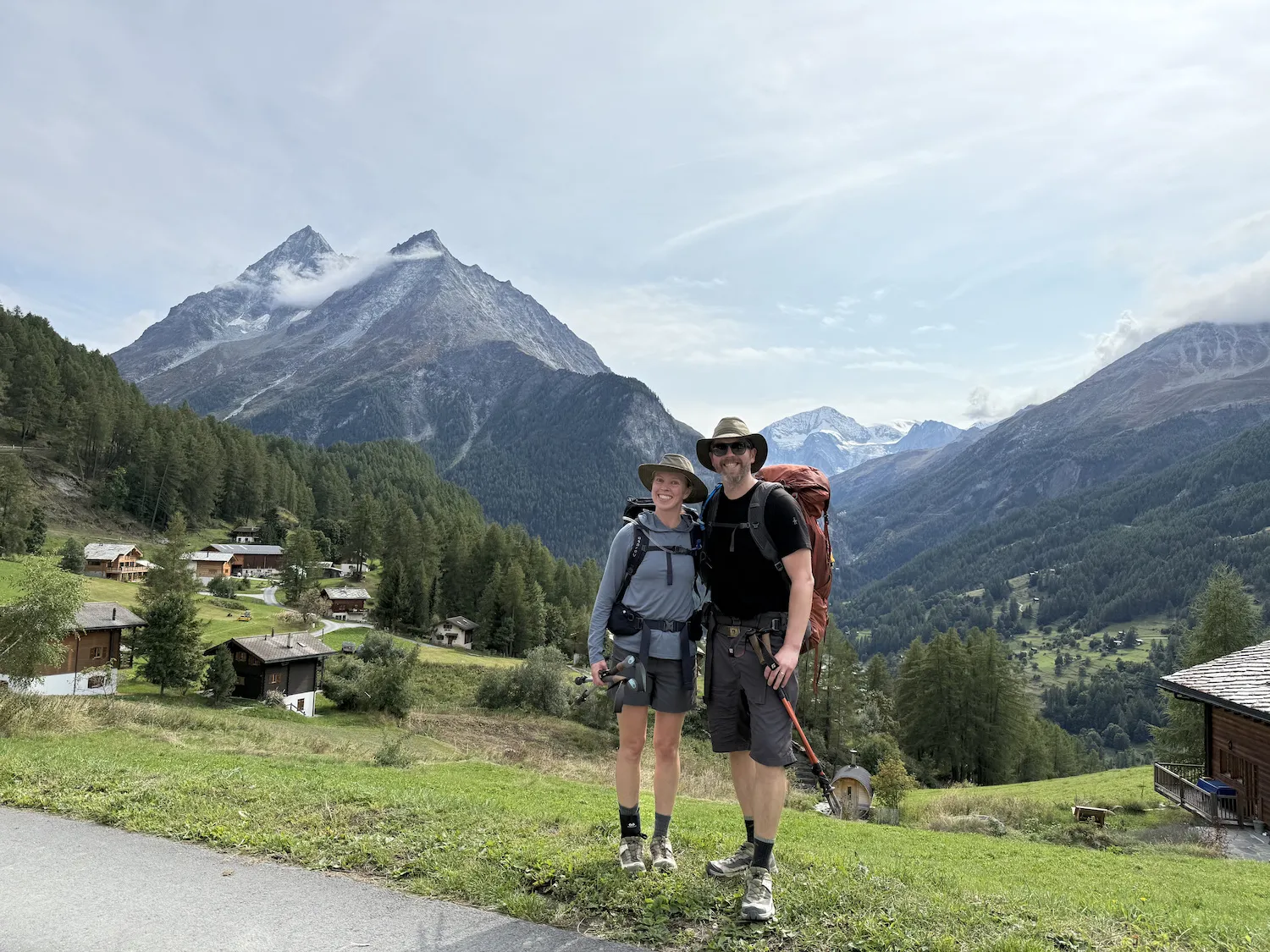 Man and woman in front of small town and mountains