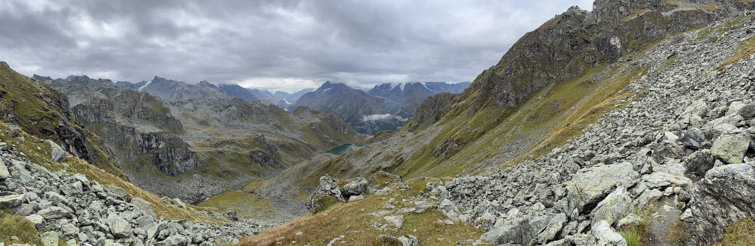 Panoramic of rocks, lake in the distance, and mountains