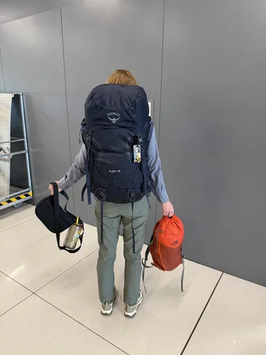 Back of woman with large backpack and two smaller bags